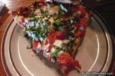 Pizza with fresh basil, mushrooms, roasted peppers, and pepperoni